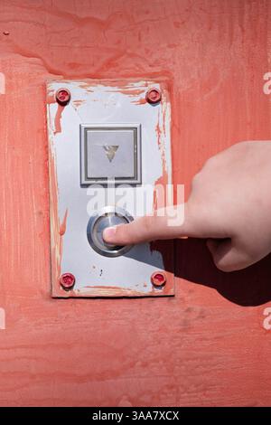 Close up hand pushing button on red door Stock Photo