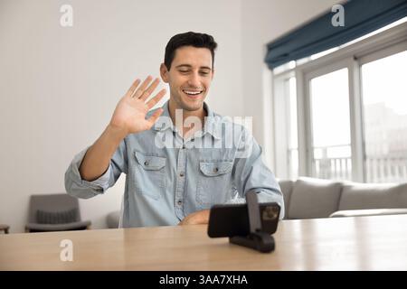 Young man participating in virtual meeting or videocall using smartphone Stock Photo