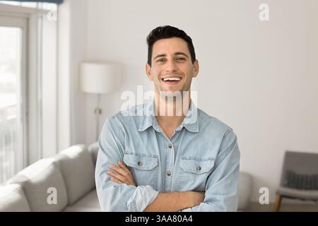Hispanic man standing in contemporary living room Stock Photo