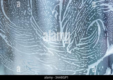 soap foam pattern wipe marks on window glass, window cleaning , blue background. High quality photo Stock Photo