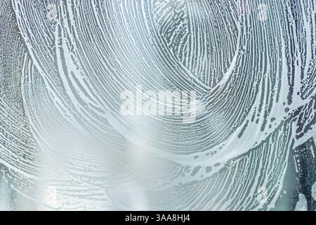 soap foam pattern wipe marks on window glass, window cleaning , blue background. High quality photo Stock Photo