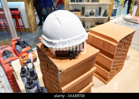 Builder safety helmet, tools and bricks in a building materials store Stock Photo