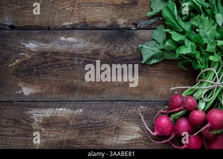 A bunch of fresh red radishes on top of rustic wooden table with copy space Stock Photo