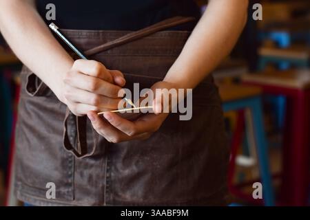 Female server writing down customer order on note pad Stock Photo
