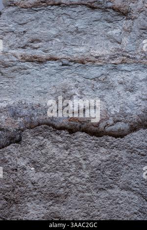 Closeup of a weathered bricks stone wall cracks and patina. Rough rustic texture and details of the aged surface, perfect for use in background and de Stock Photo