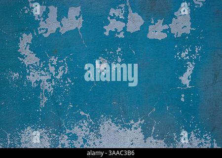 Peeling paint and cracked blue wall texture background. Weathered decayed urban surface with chipped paint and cracks. Distressed, rustic aesthetic fo Stock Photo