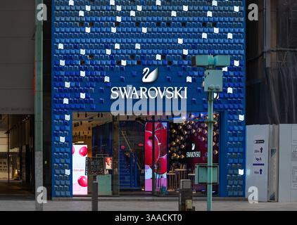 tokyo, ginza - jan 08 2024: Swarovski Ginza store featuring a striking blue facade with glowing geometric patterns and a prominent swan logo, attracti Stock Photo