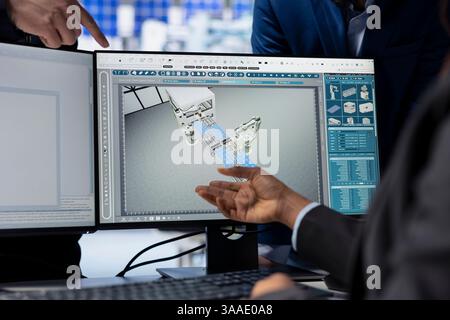 Solar energy production facility programmer writing software code on computer, developing tools to manage robotic machinery operations under supervisor surveillance, close up shot Stock Photo