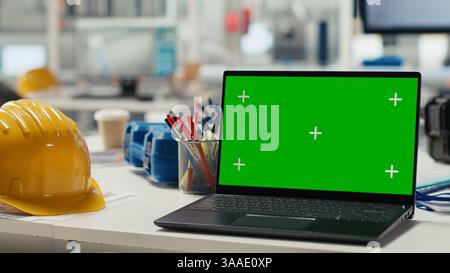 Chroma key laptop in photovoltaics factory used to monitor system performance. Green screen monitor tracking solar panels manufacturing plant energy production and efficiency, close up Stock Photo