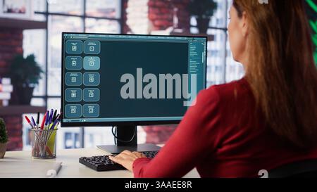 Focused woman working with an AI chatbot on her desktop computer, offering real time assistance and powerful online tools. Advanced system displays how machine learning provides support. Camera A. Stock Photo