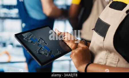 Photovoltaic smart factory specialist uses tablet to design production lines in CAD software. Industry 4.0 solar panels plant employee uses device to optimize floor layouts, camera A close up Stock Photo