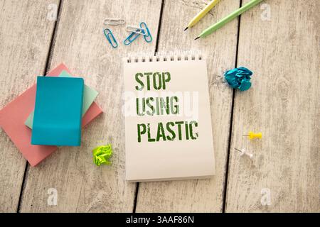 Woman hand holding brown paper bag on green background. Stop using plastic bags. Eco friendly concept. Stock Photo