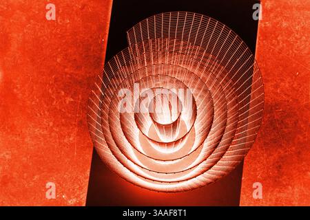 Abstract spiral with glowing red and orange tones and wire texture against a black background, symbolizing energy, motion, industrial and futuristic d Stock Photo