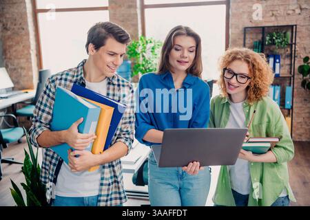 Young enthusiastic coworkers collaborating on a project in a modern office workspace, embracing team spirit and innovation Stock Photo