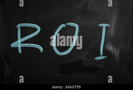 The word ROI handwritten with white chalk on a blackboard Stock Photo