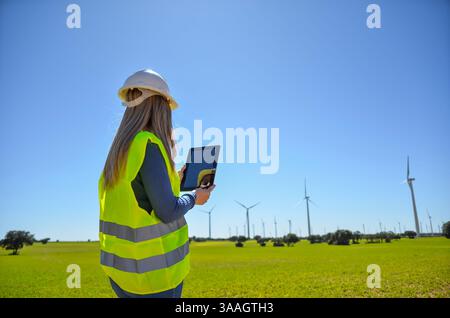 Engineer using tablet working in a wind turbine power plant checking data with digital tablet Stock Photo