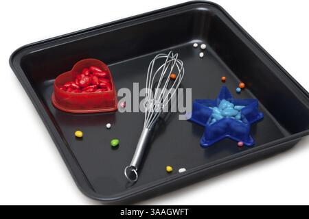 Form for baking, plastic red heart with sweetmeat and blue star, on white background Stock Photo