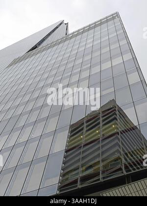 Modern glass facade of a skyscraper with reflections on the windows in London, England, Great Britain Stock Photo
