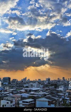 View of the city at sunset, the sun breaks through the clouds Stock Photo