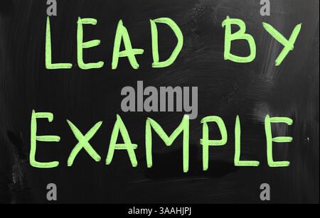 Lead by example handwritten with white chalk on a blackboard Stock Photo
