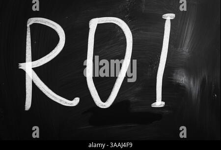 The word ROI handwritten with white chalk on a blackboard Stock Photo