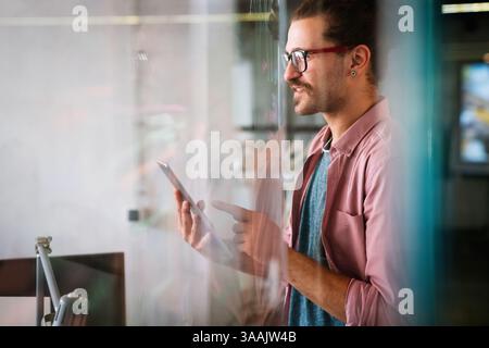 Leadership, tablet and hipster startup programmer CEO or manager in the office. Technology planning. Stock Photo
