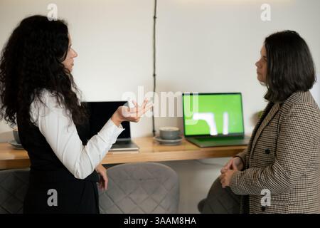 Business conversation between two women at coworking. Stock Photo