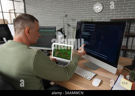 Mature male programmer working in office Stock Photo