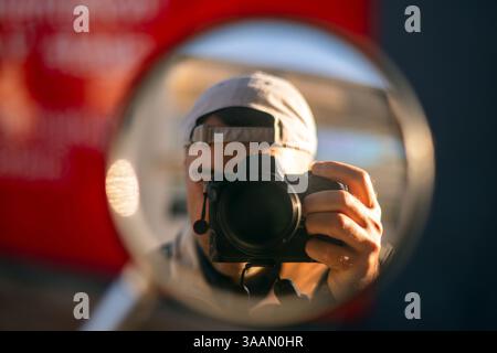 man with a camera reflection in a miror Stock Photo