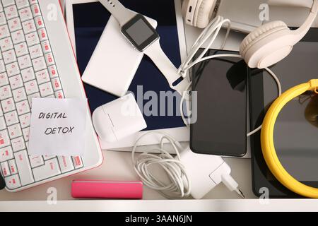 Different gadgets and sticky note with text DIGITAL DETOX in open drawer, closeup Stock Photo