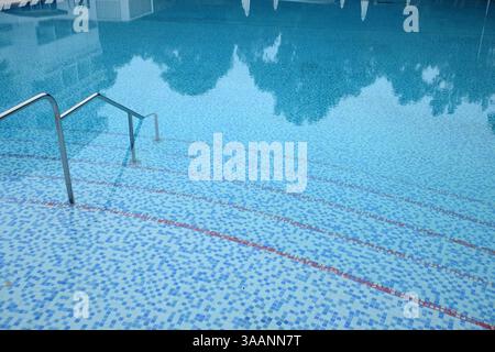 Empty open air swimming pool with clean blue water and line marking on bottom in resort hotel Stock Photo