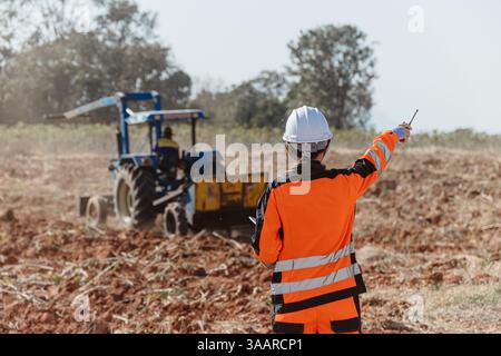 Builder engineer worker outdoor working in construction site wearing safety suit control operate land leveling process for land development Stock Photo