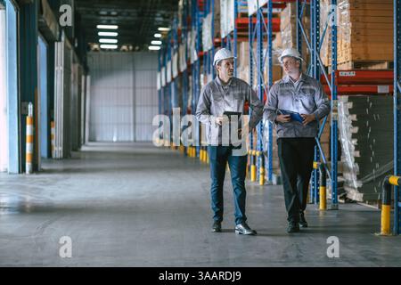 Warehouse workers working together, Staff inventory employee team in duty in storage warehouse building with safety suit Stock Photo