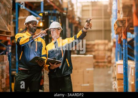 Warehouse workers working together, Staff inventory employee team in duty in storage warehouse building with safety suit Stock Photo