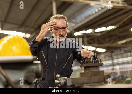 Senior worker tired exhausted headache pain suffer from hard work in heavy industry factory. Stock Photo