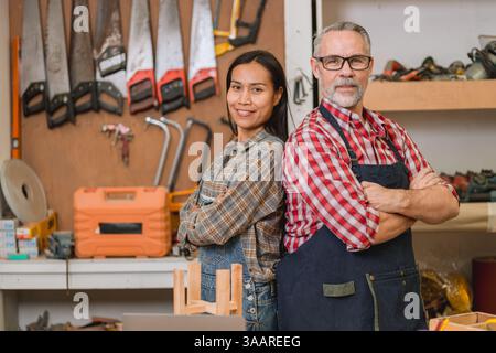 Portrait Professional carpenter team standing confident Happy smile work design furniture in workshop in wood factory Stock Photo