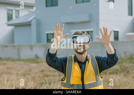 Engineer male worker using Visual reality VR or Augmented reality AR technology in construction industry. Modern digital innovation in engineering con Stock Photo