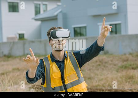 Engineer male worker using Visual reality VR or Augmented reality AR technology in construction industry. Modern digital innovation in engineering con Stock Photo