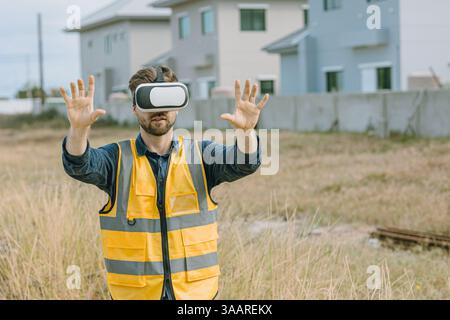 Engineer male worker using Visual reality VR or Augmented reality AR technology in construction industry. Modern digital innovation in engineering con Stock Photo