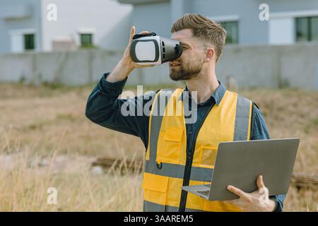 Engineer male worker using Visual reality VR or Augmented reality AR technology in construction industry. Modern digital innovation in engineering con Stock Photo