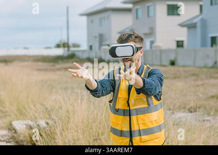 Engineer male worker using Visual reality VR or Augmented reality AR technology in construction industry. Modern digital innovation in engineering con Stock Photo