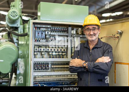 Portrait Senior Professional Electrician engineer supervisor service maintenance check heavy industry machine electricity wire cable Stock Photo