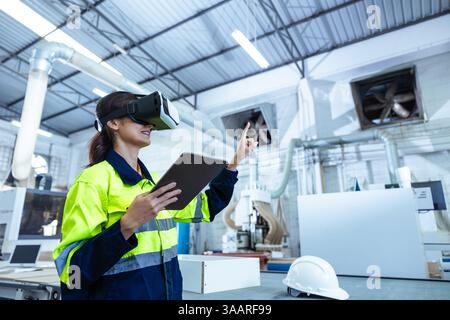 Modern Factory Innovation Technology in Industry, Technician female using VR Virtual Reality Headset in Wood furniture design workshop. Stock Photo