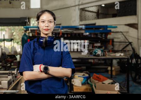 Portrait engineer women working in Lathe shop with metal machinery lathe milling machine, confident smart looking camera. Stock Photo
