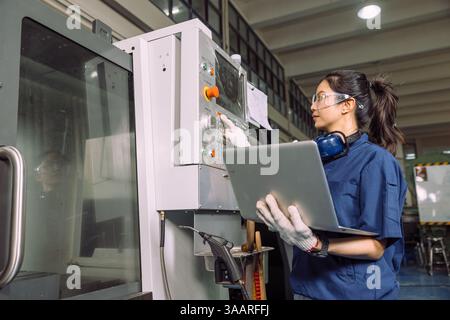 Engineer women working in Lathe shop with Digital CNC metal lathe milling machine, expert skillful industry worker female. Stock Photo