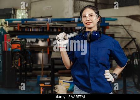 Portrait engineer women working in Lathe shop with metal machinery lathe milling machine, confident smart looking camera. Stock Photo