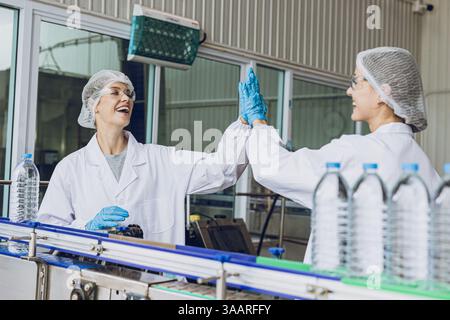 Happy workers working in drinking water factory in production live enjoy work together and smile Stock Photo