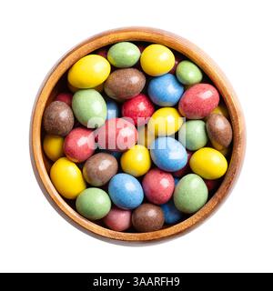 Candy coated milk chocolate peanuts in a wooden bowl. Roasted peanuts, coated with milk chocolate, with multi-colored sugar coating. Stock Photo