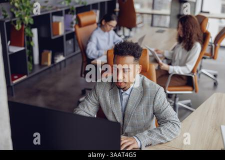 A modern workspace featuring professionals actively engaged in collaborative and innovative work Stock Photo