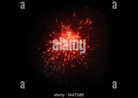 Single Red Firework Burst Against Night Sky Stock Photo